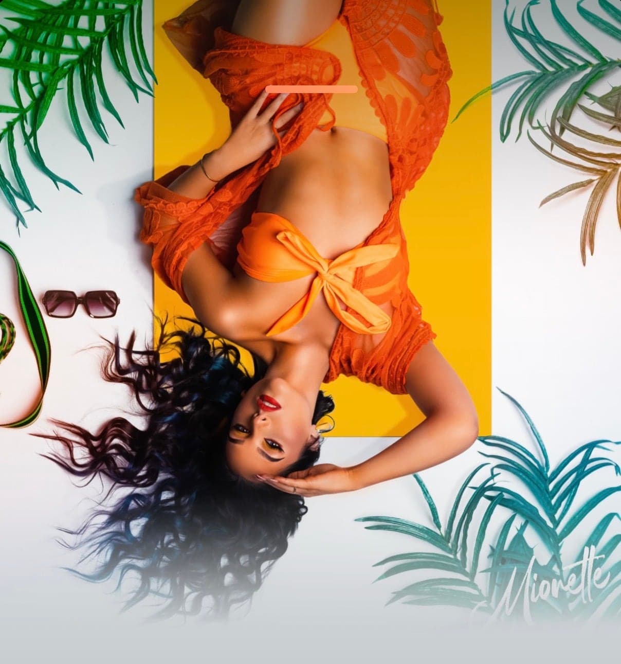 Mionette cover artwork, upside down in orange among palms