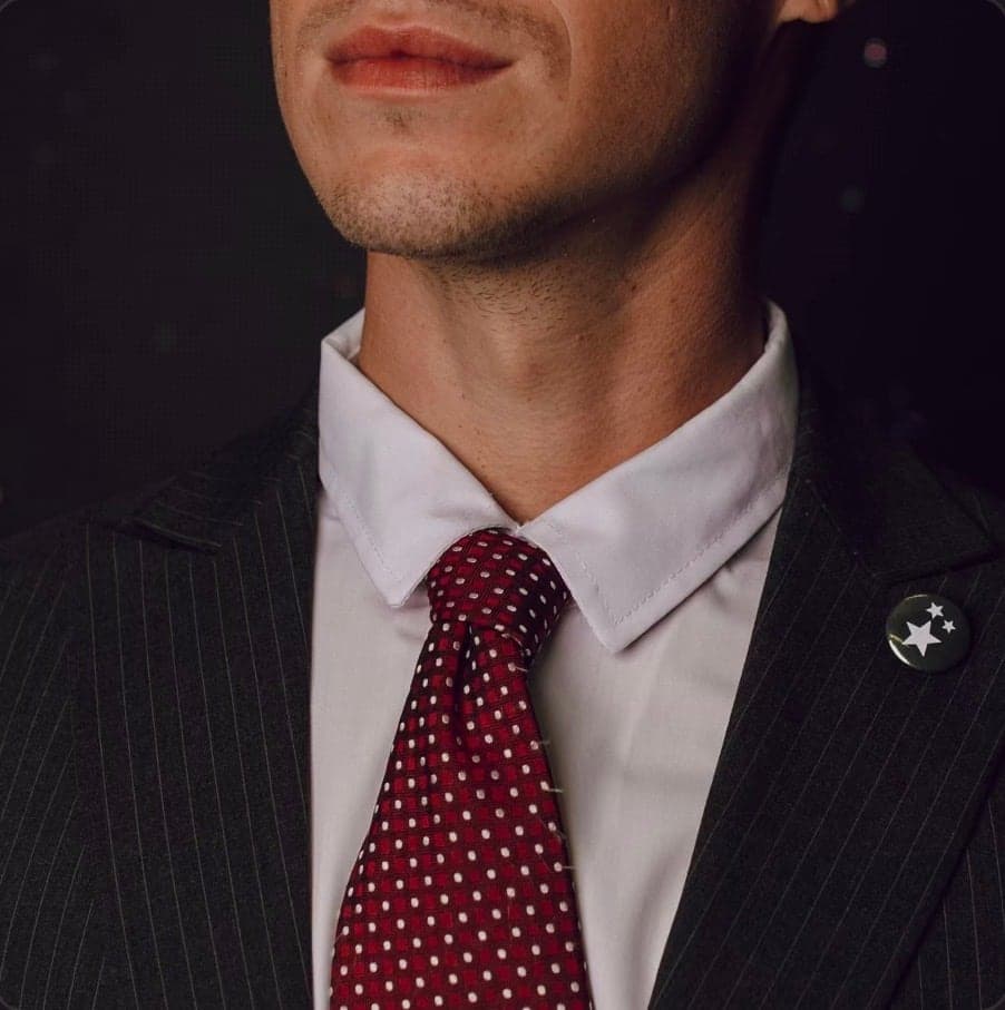 Cover artwork, a close crop of a suit and red tie