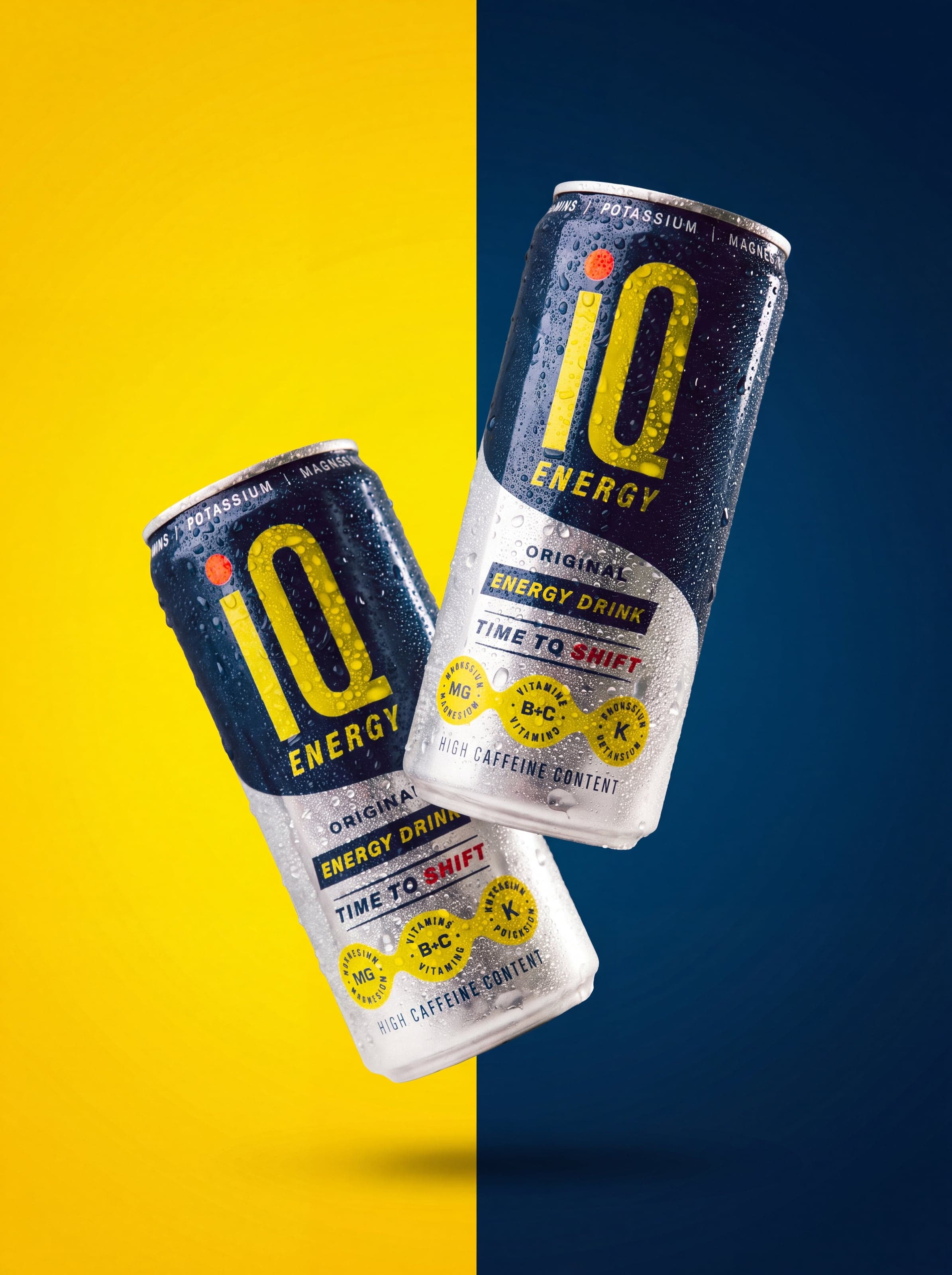 Two IQ Energy cans floating across a yellow and navy split