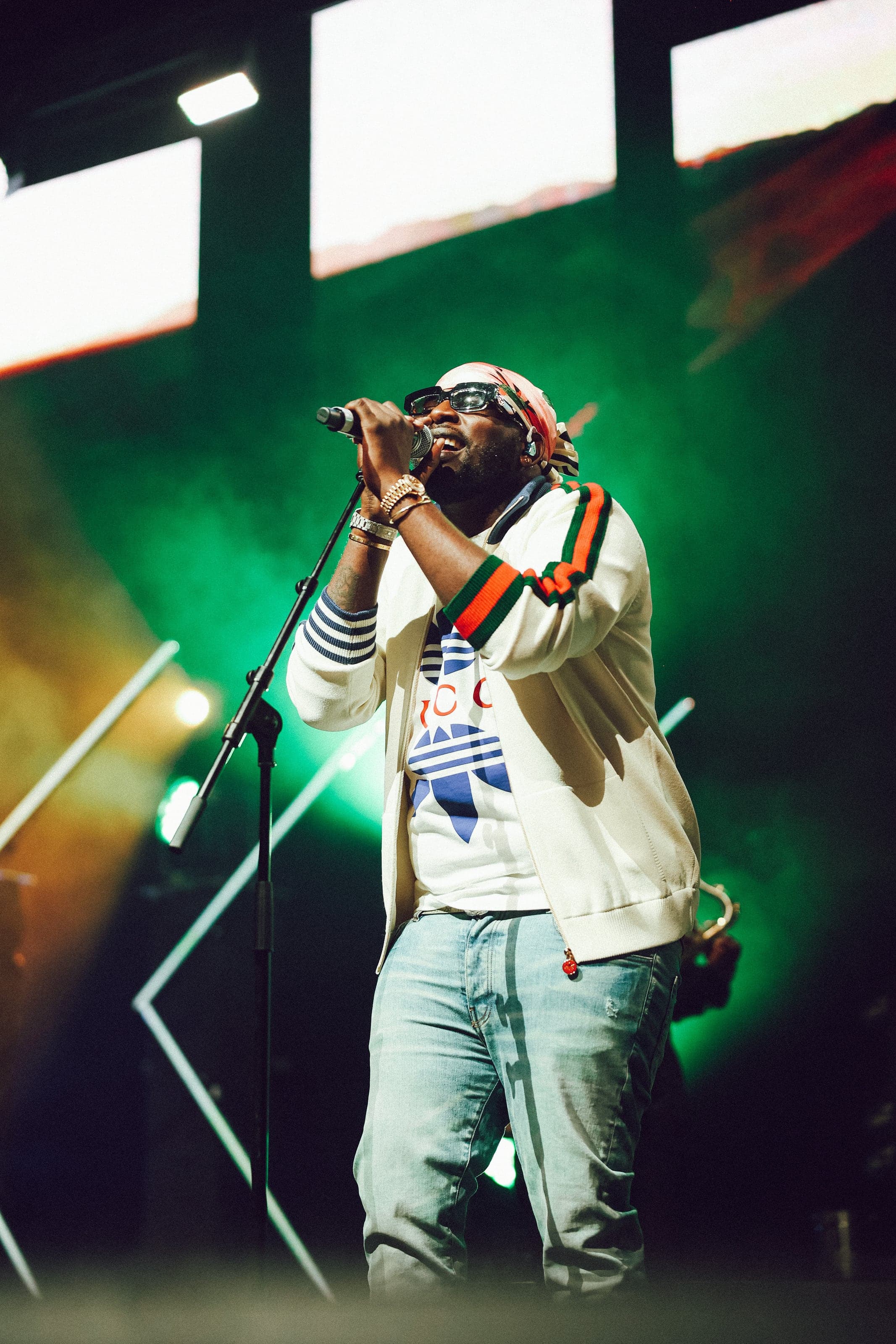 Rapper at the mic under green stage light