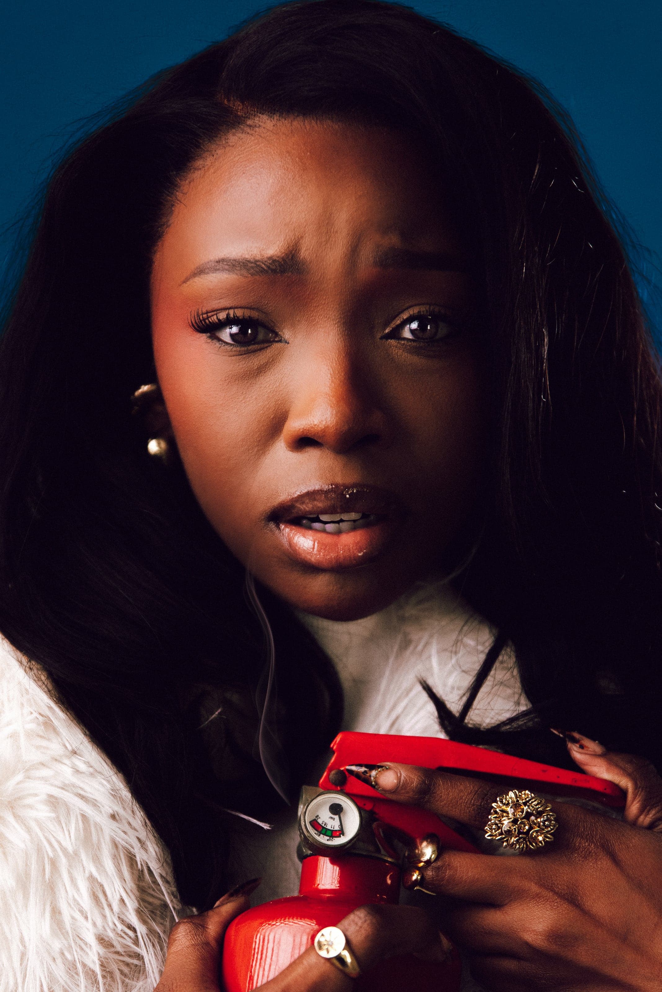 Woman with a red camera, startled expression, blue backdrop