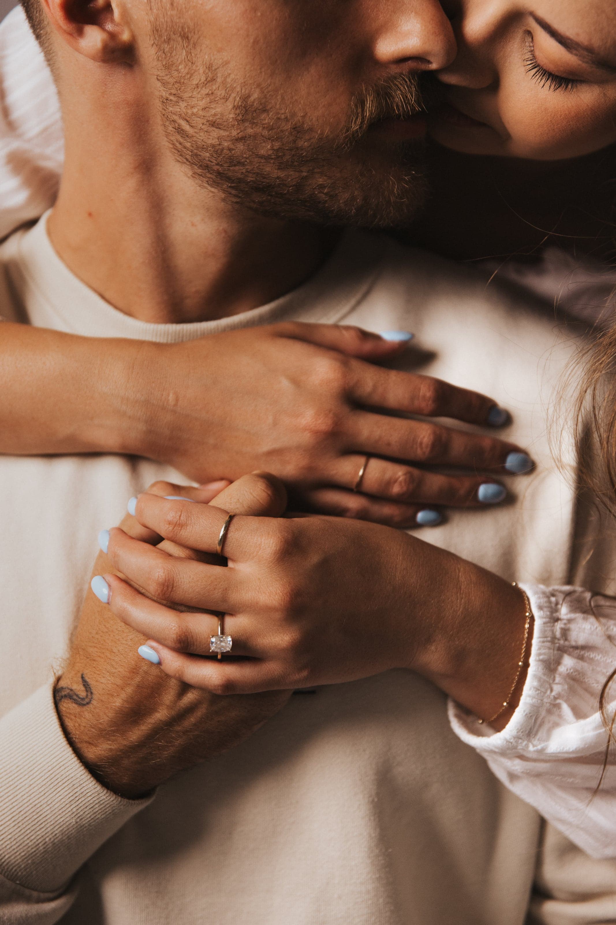 Close detail of hands and an engagement ring