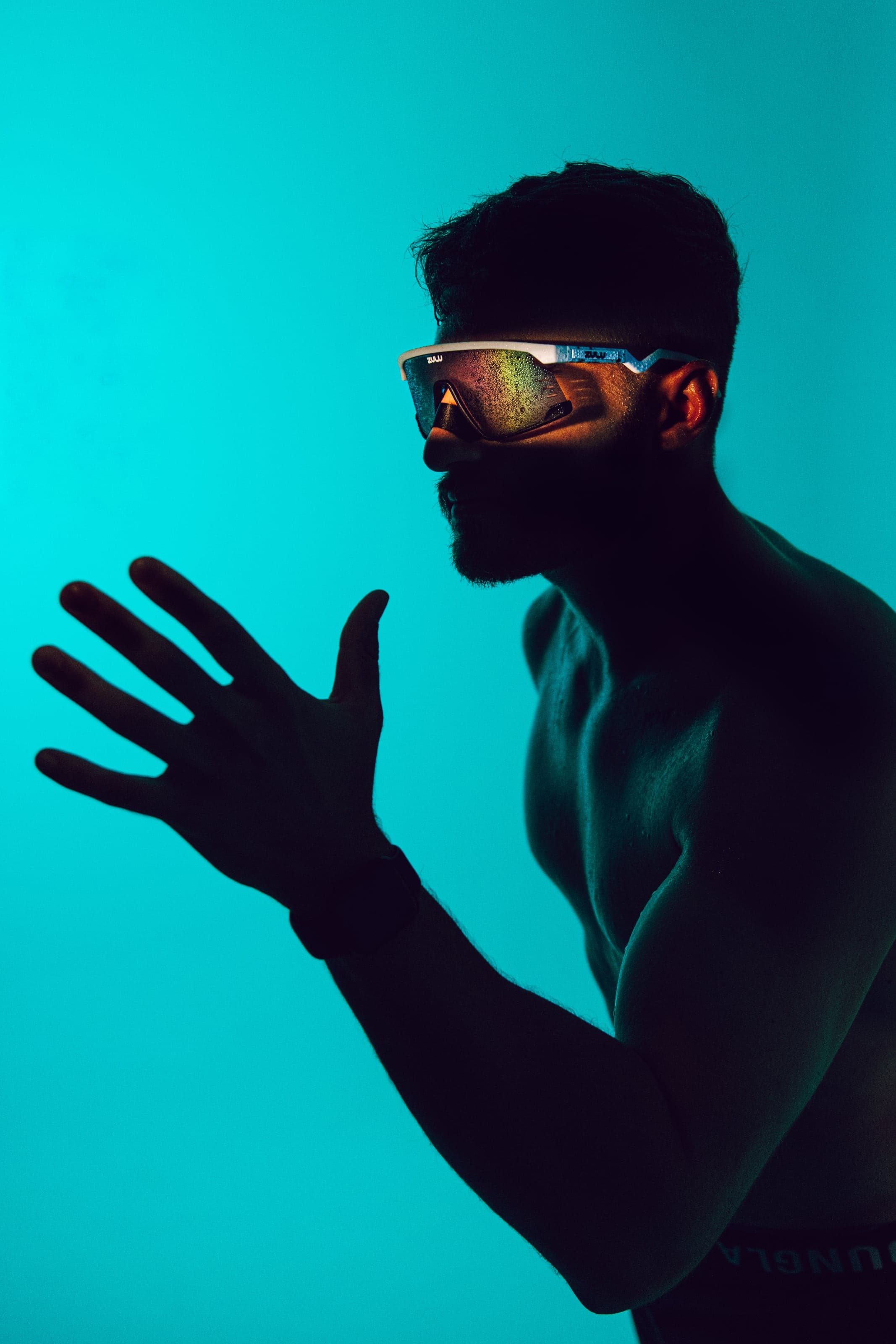 Silhouetted athlete against turquoise light in Zulu glasses